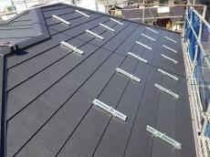 屋根カバー工法の施工完了後、太陽光パネルを取り付けていきます。今回の屋根材に対応した専用架台金具を使用しました。