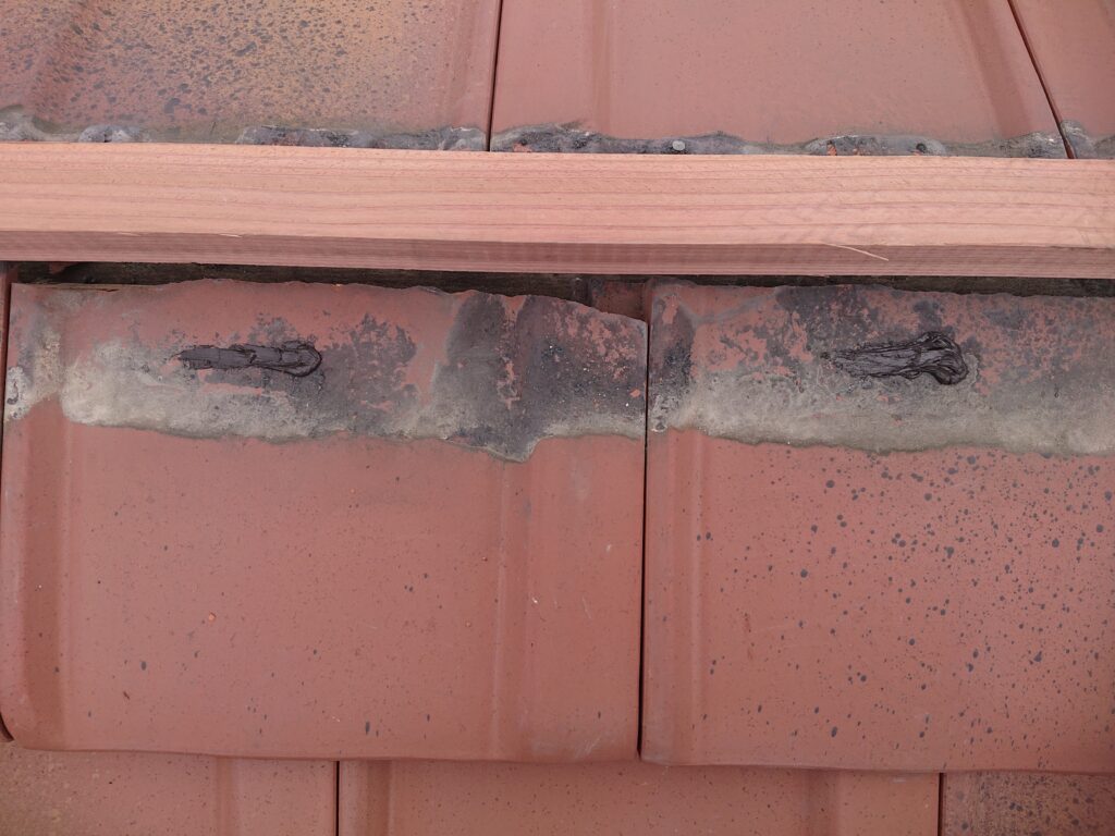 棟際のカットしてある桟瓦の釘位置が雨水が浸入してくる箇所であった為、コーキングにて防水を行いました。